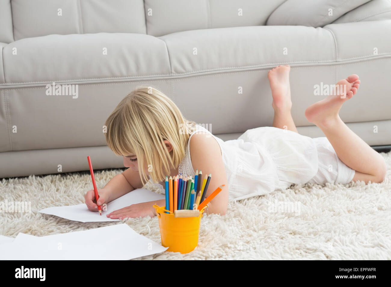 Smiling litlle girl drawing lying on the floor Stock Photo - Alamy