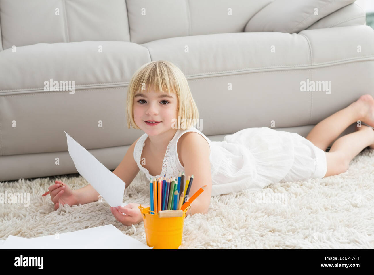 Smiling litlle girl drawing lying on the floor Stock Photo - Alamy