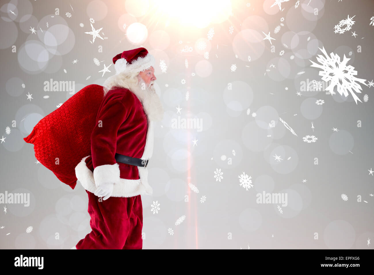Composite image of santa claus carrying sack Stock Photo
