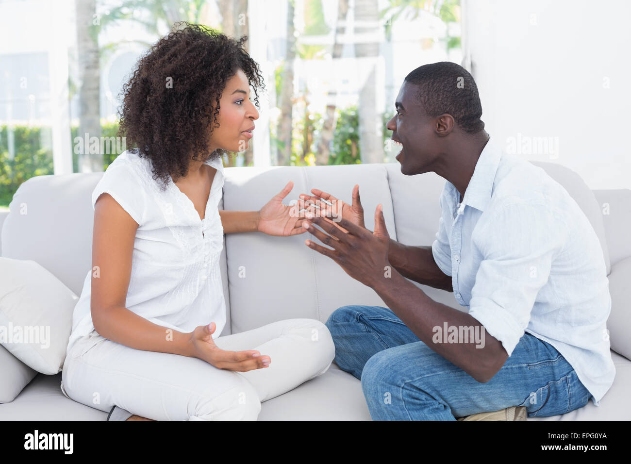 Attractive couple having an argument on couch Stock Photo - Alamy