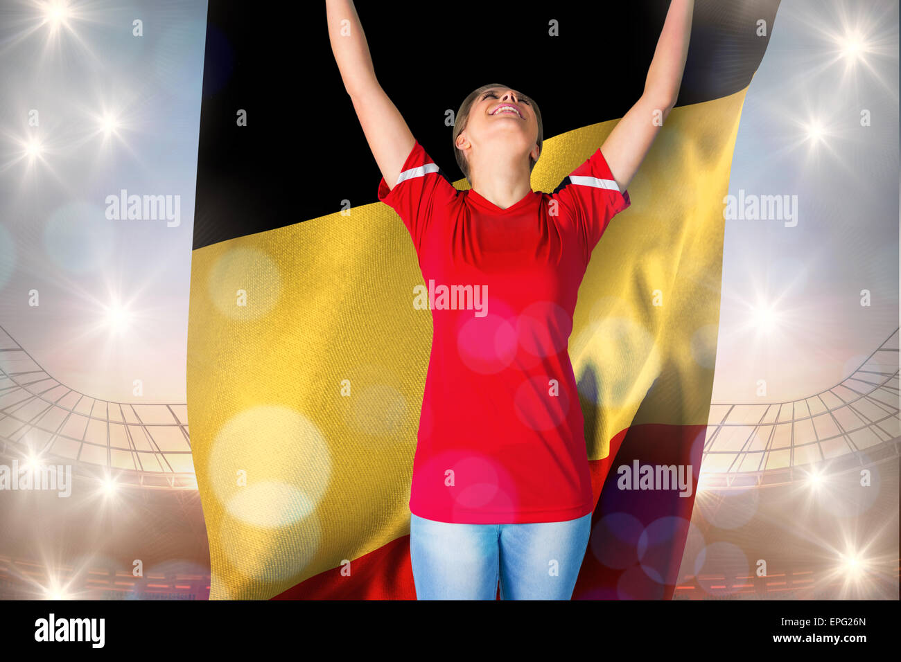 Composite image of cheering football fan in red holding belgium flag ...