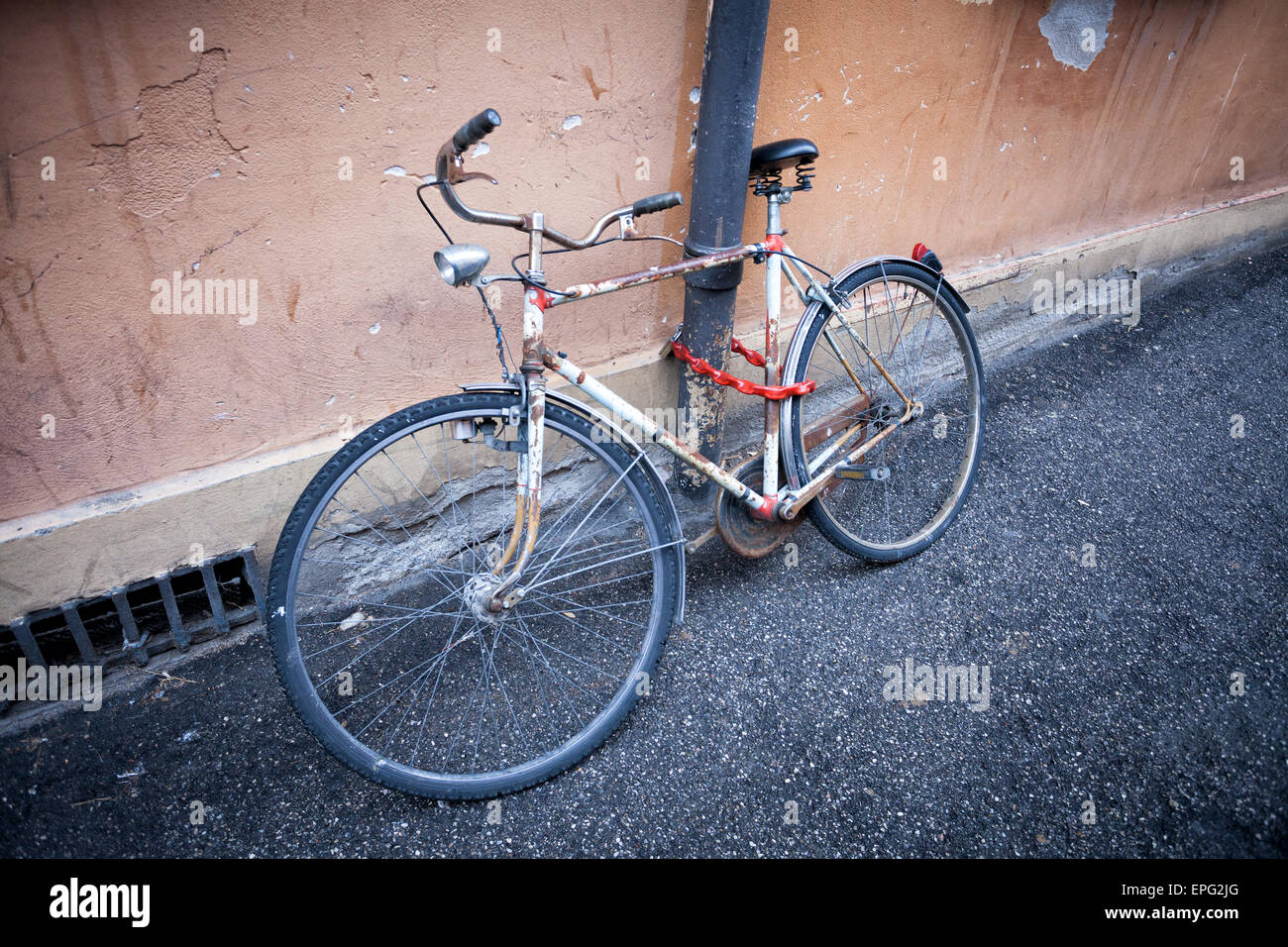 old rusty vintage bicycle near the concrete wall Stock Photo