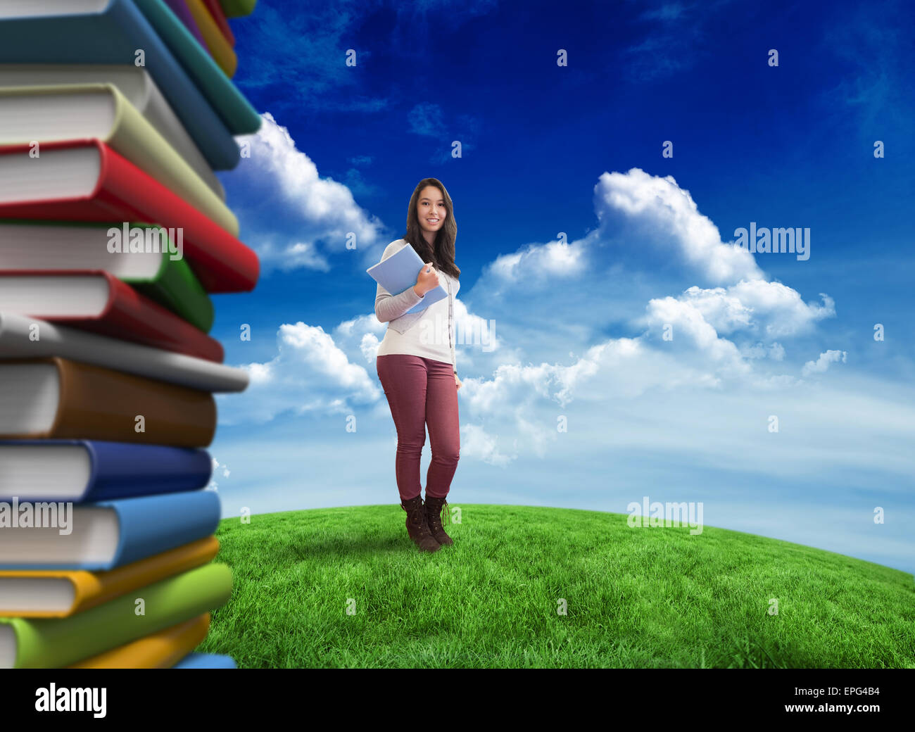 Composite image of smiling student holding textbook Stock Photo - Alamy