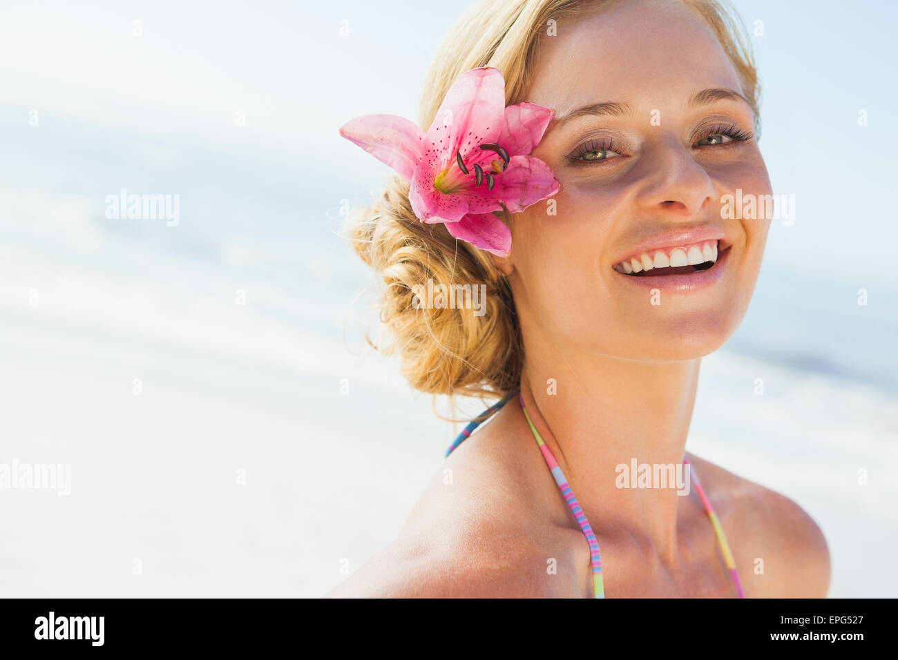 Gorgeous blonde in bikini smiling at camera on the beach Stock Photo ...