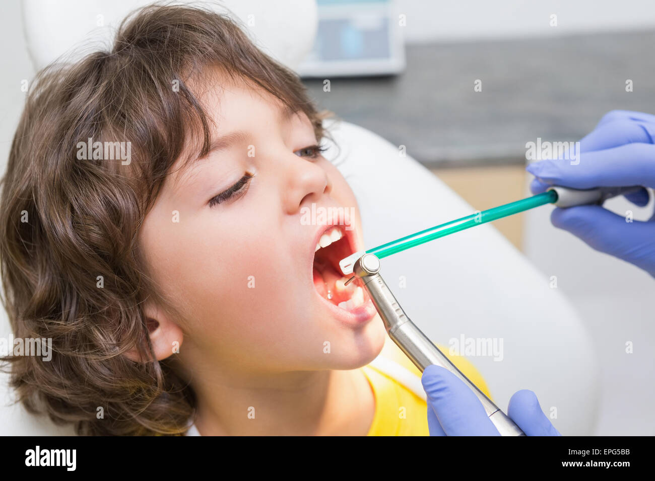 Pediatric dentist examining a little boys teeth in the dentists chair Stock Photo