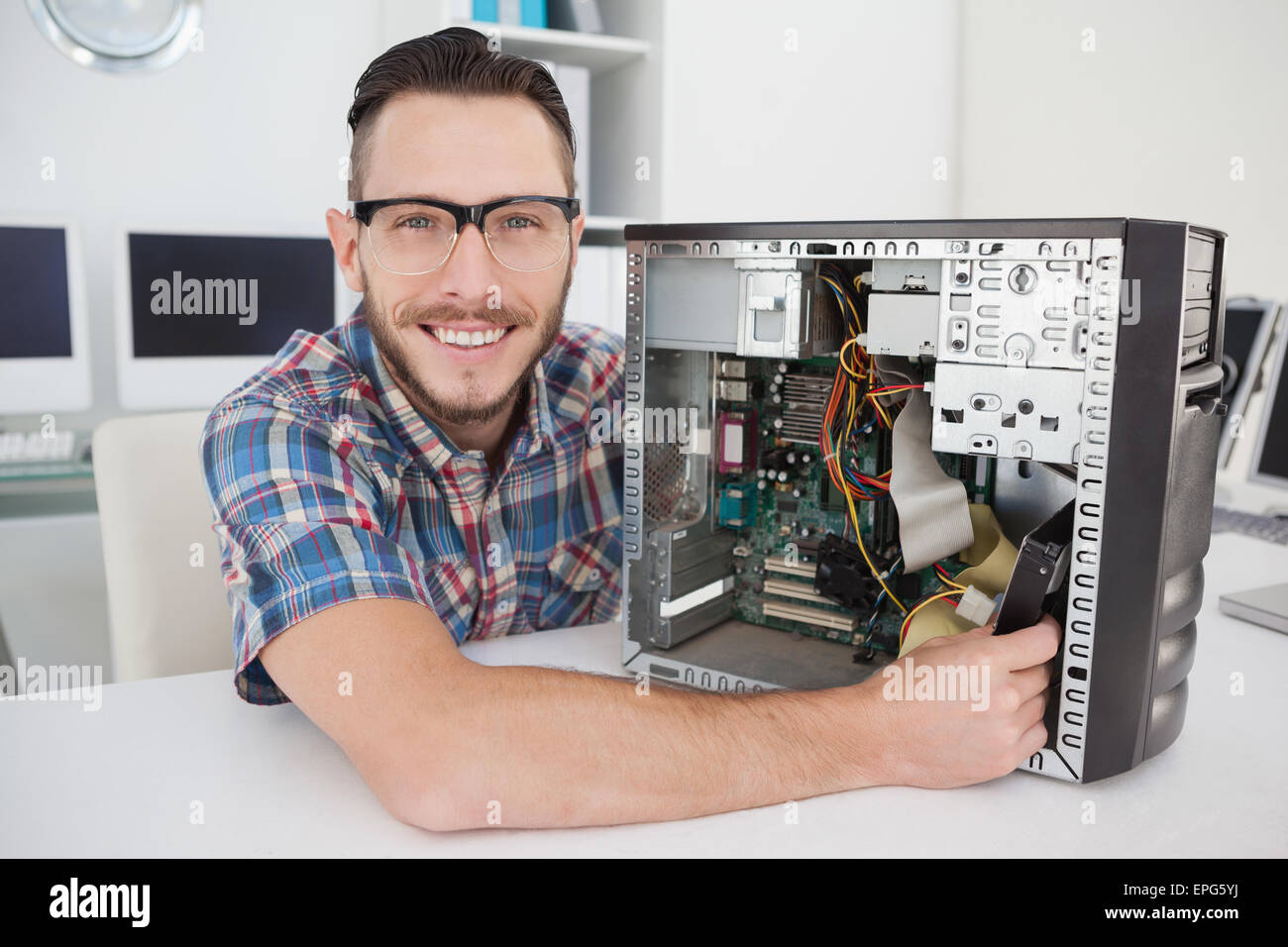 Computer engineer working on broken console smiling at camera Stock ...