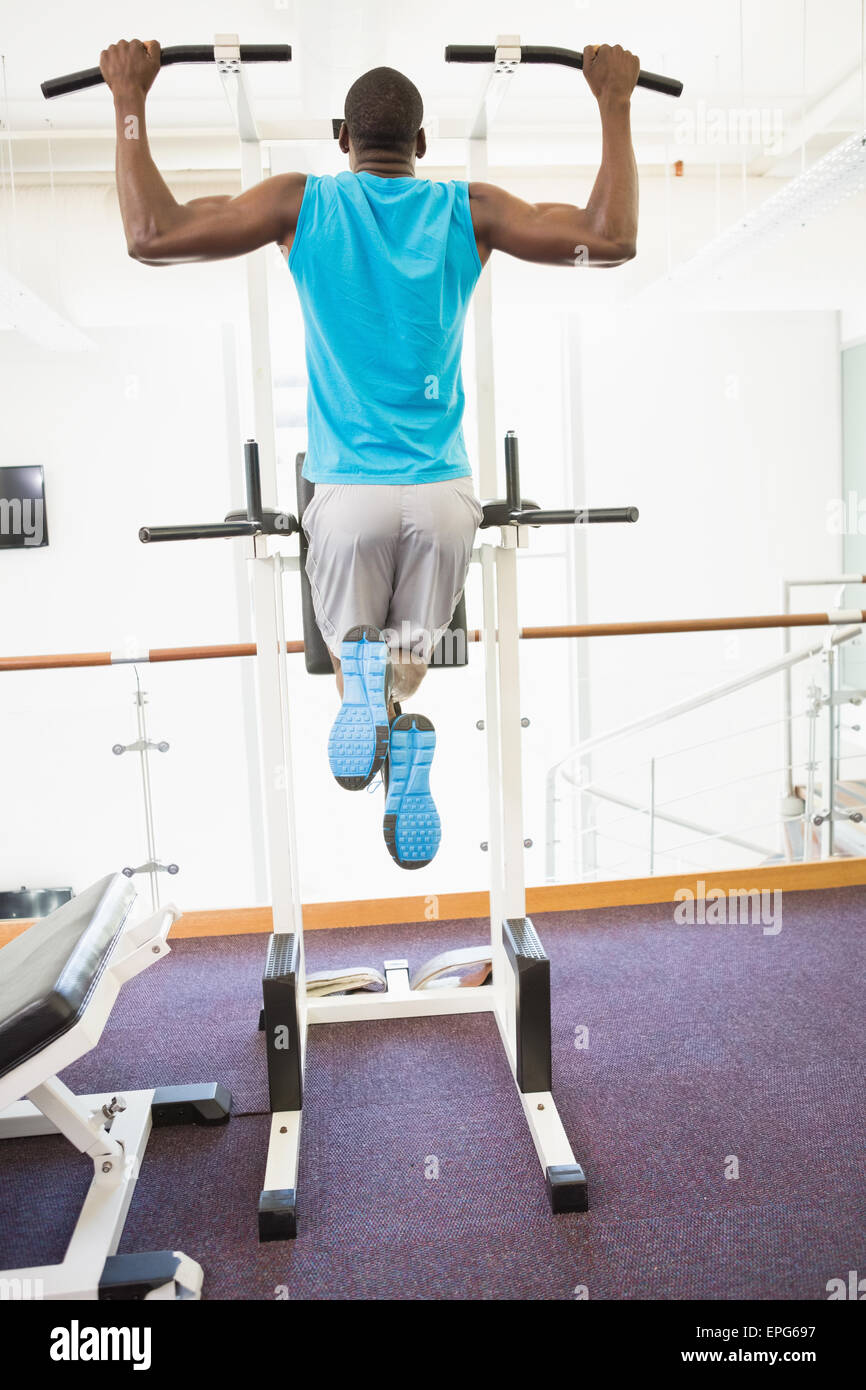 Rear view of muscular man doing pull ups at gym Stock Photo - Alamy