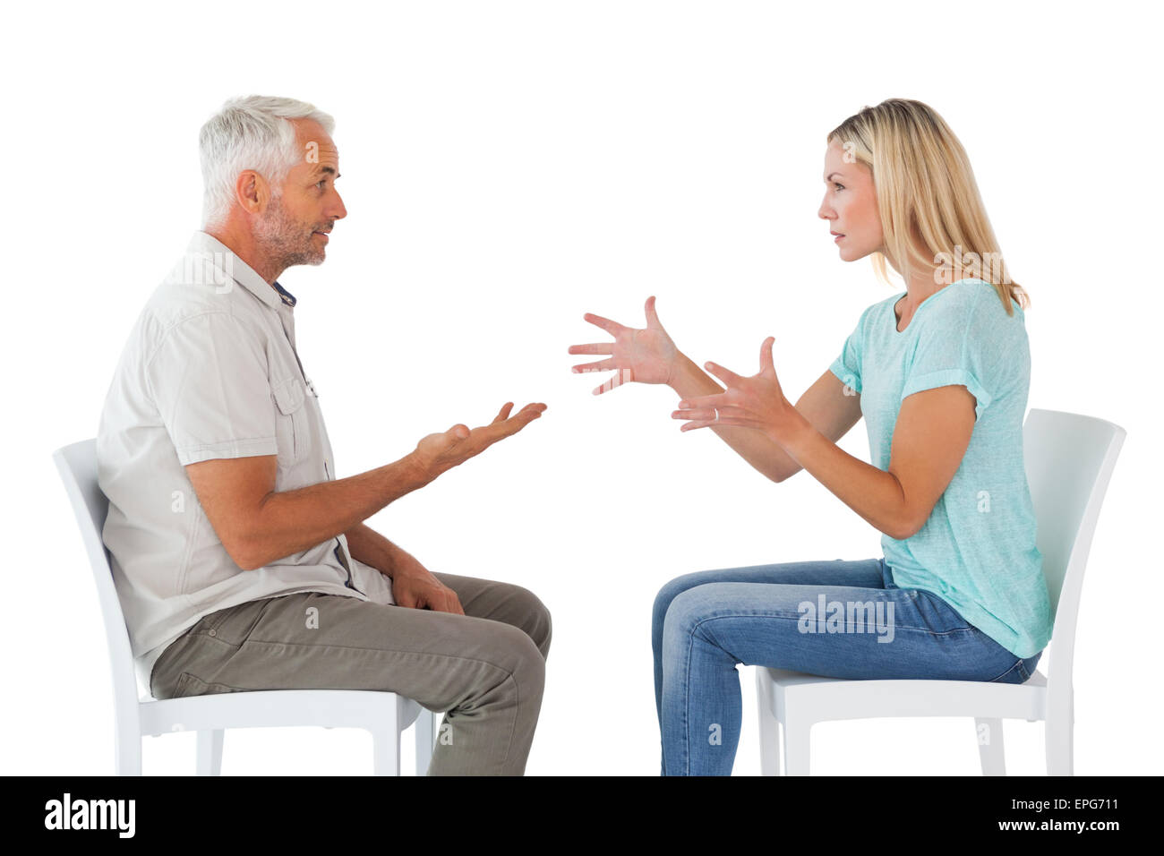Unhappy couple sitting on chairs having an argument Stock Photo - Alamy