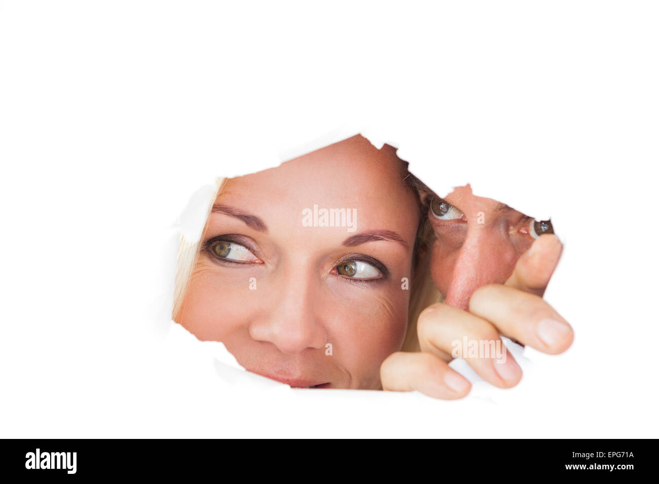 Couple looking through torn paper Stock Photo