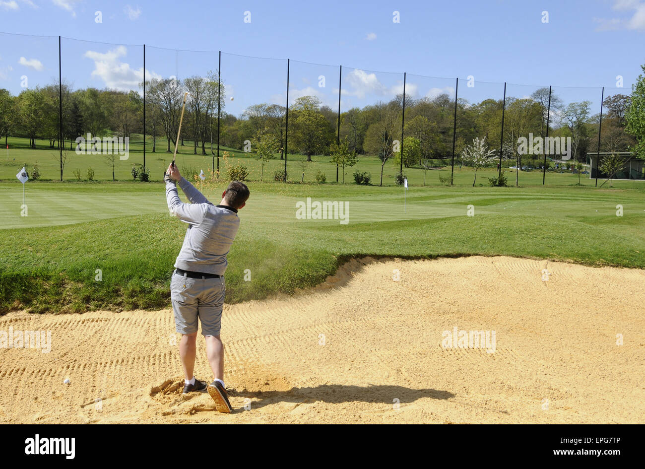 Male Golfer playing from a Bunker at the Practice Ground at Sundridge Park Golf Club Bromley Kent England Stock Photo