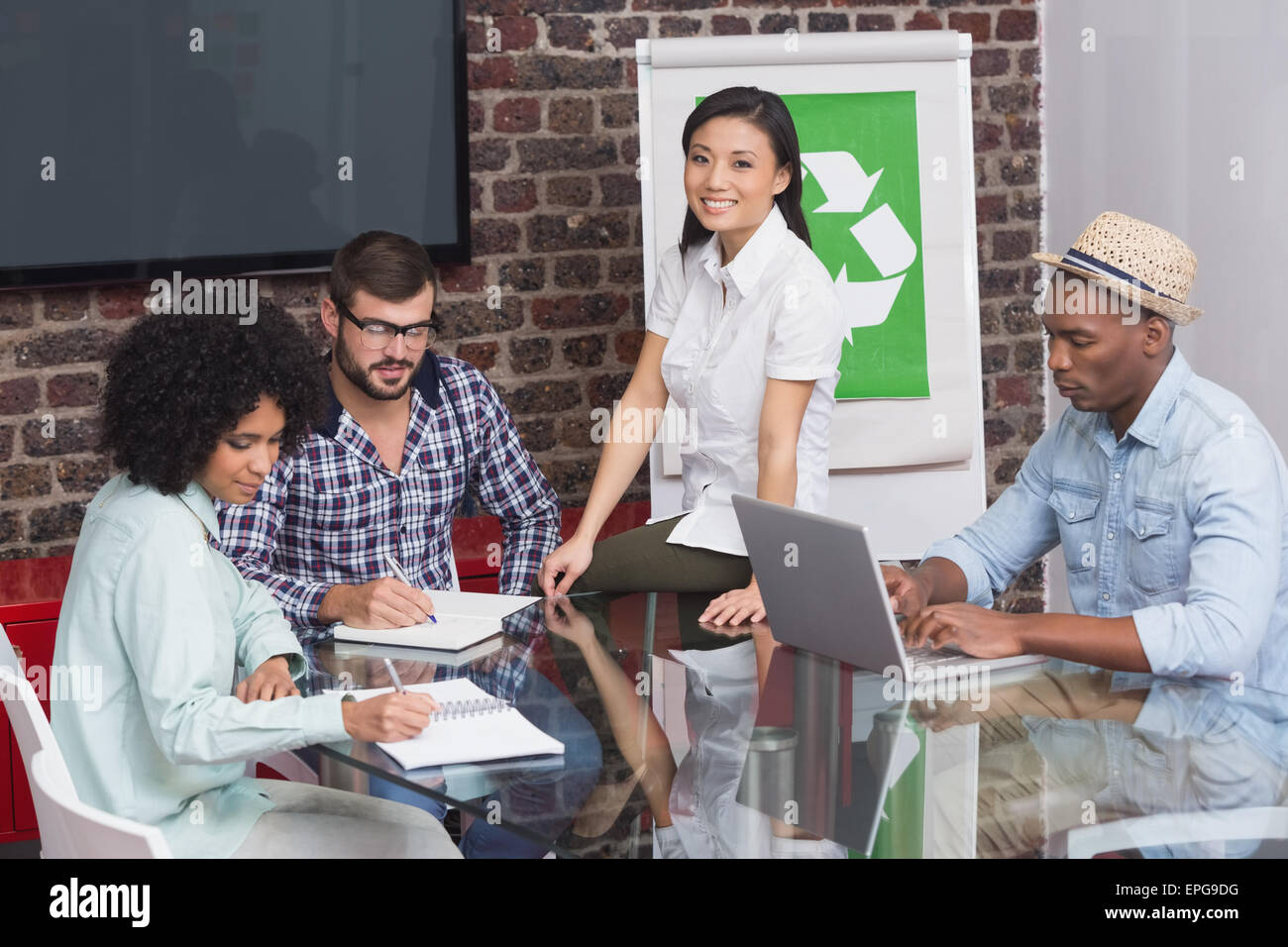Team in meeting with recycling symbol on whiteboard Stock Photo
