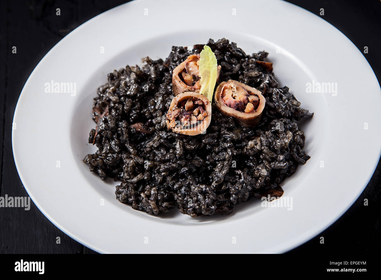 seafood risotto with black calamari ink on white plate Stock Photo