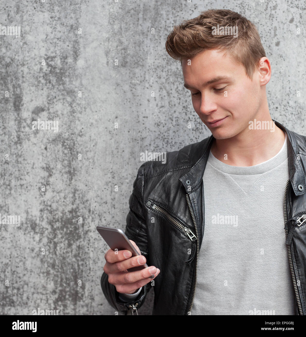 Casual young guy using smart phone Stock Photo