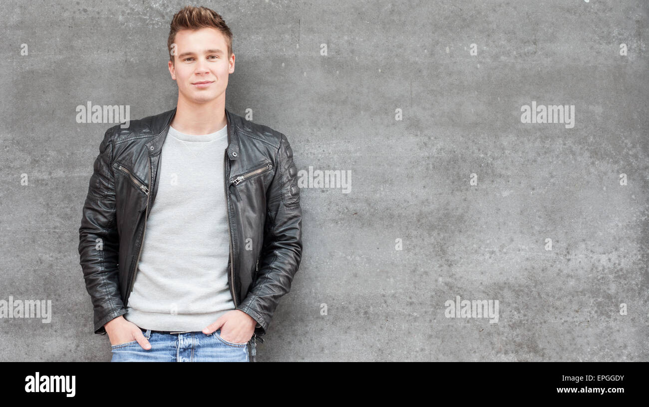 Casual young guy in front of concrete wall Stock Photo