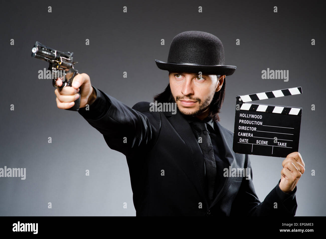 Man with gun and movie clapboard Stock Photo - Alamy