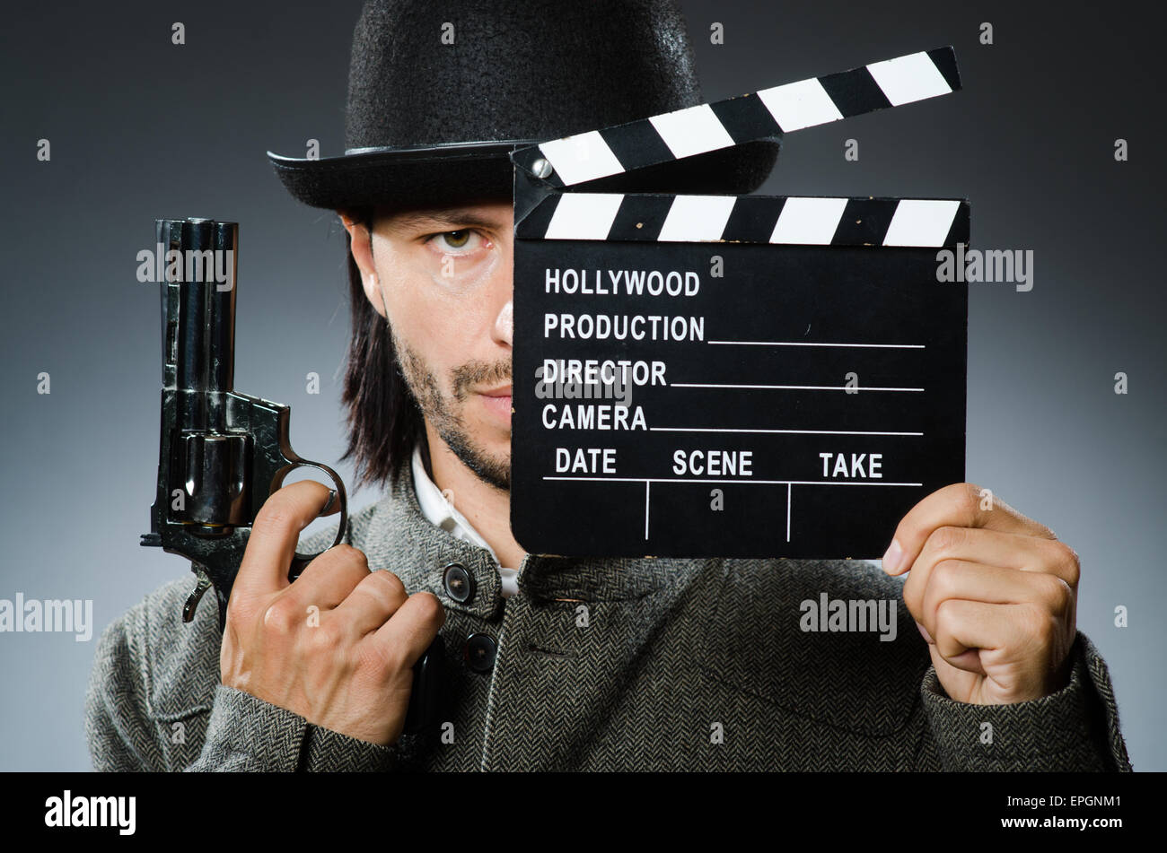 Man with gun and movie clapboard Stock Photo - Alamy