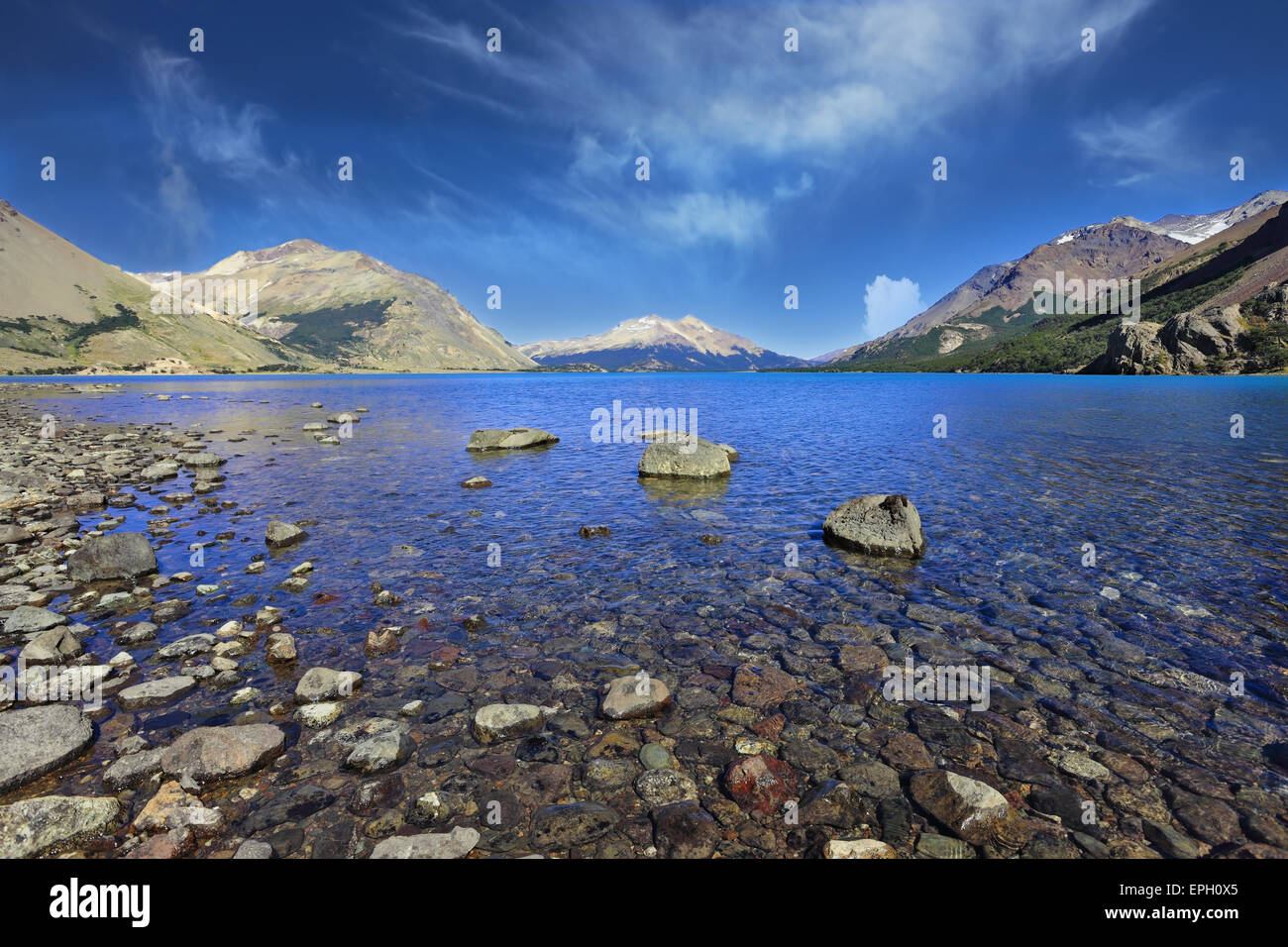 The bright blue water and rocky shore Stock Photo - Alamy