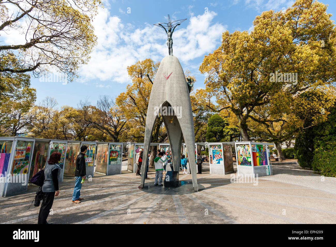 Tourists and people visiting the children's Peace Monument statue with the paper crane display behind it, in the peace Park in Hiroshima. Stock Photo