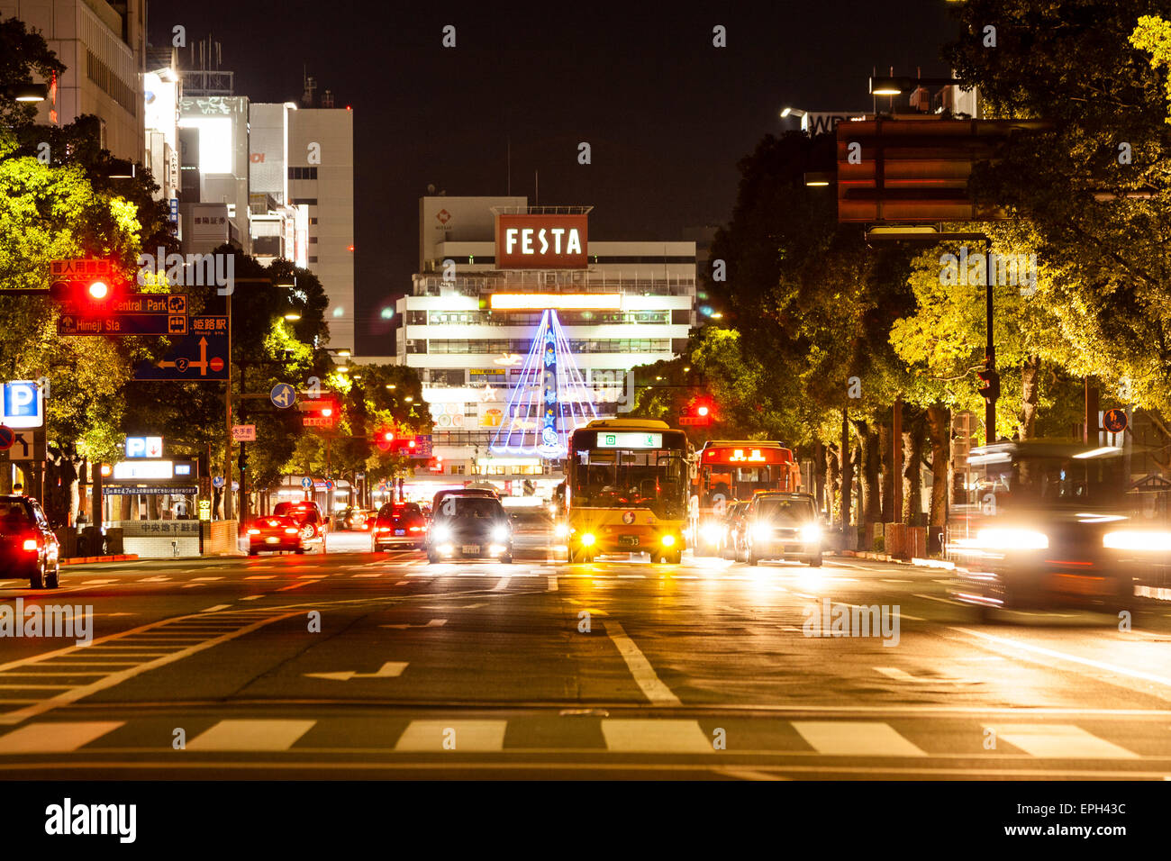 Night view along Otemaedori street with traffic waiting at the crossroads and pedestrian crossing in the foreground, and the Festa building behind. Stock Photo