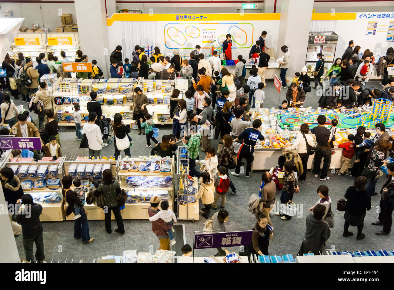 Overhead view of toy Tommy train promotional event in Osaka, Japan. Crowded hall with families looking at many stalls selling products . Stock Photo
