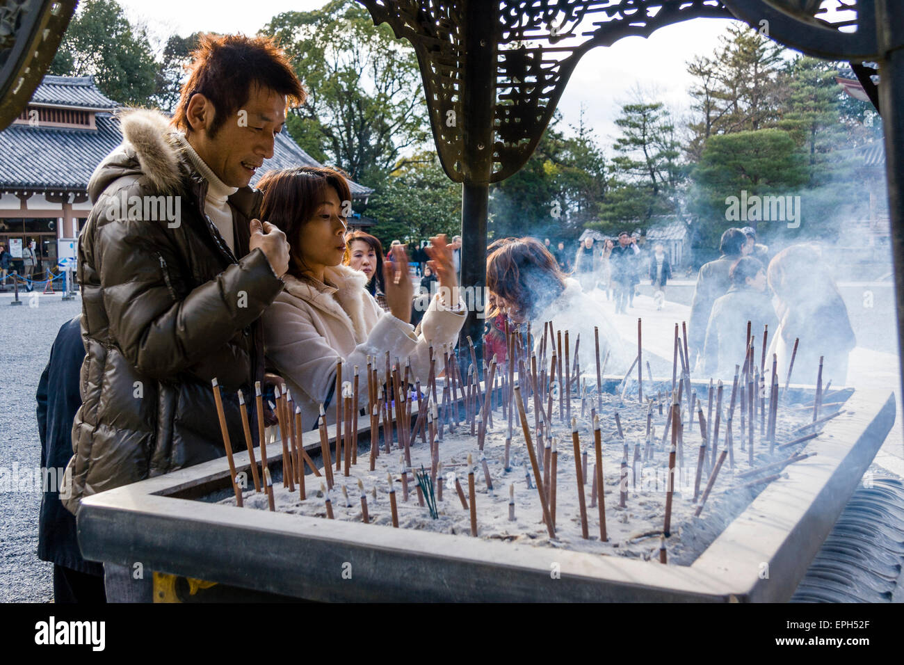 Chionin temple in Kyoto. Family standing around incense burner praying