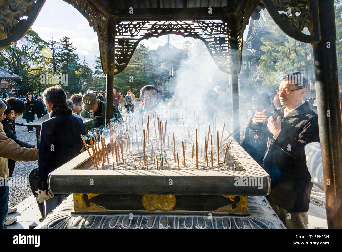 Chionin temple in Kyoto. Man standing at incense burner praying and