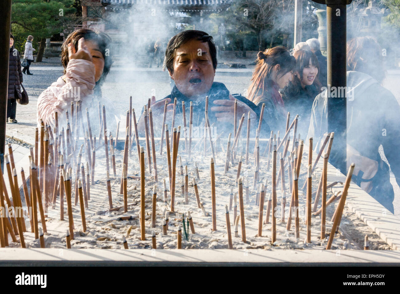 Chionin temple in Kyoto. Man standing at incense burner praying and