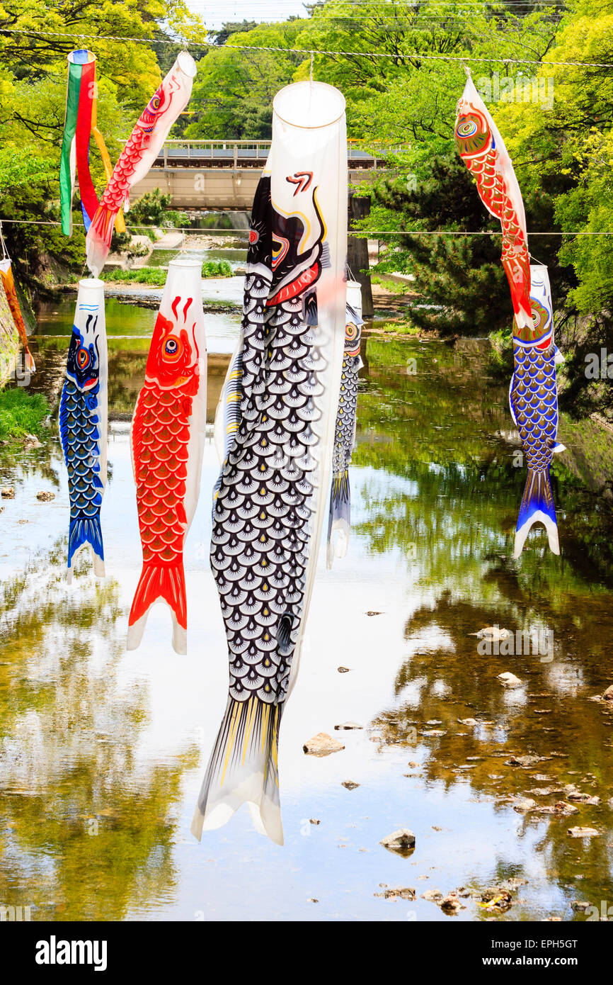 Koinobori carp banners, windsocks, hanging over a river at Kobe in Japan. Flown to celebrate Tango no sekku for children's day, kodomo no Hi, on May 5. Stock Photo