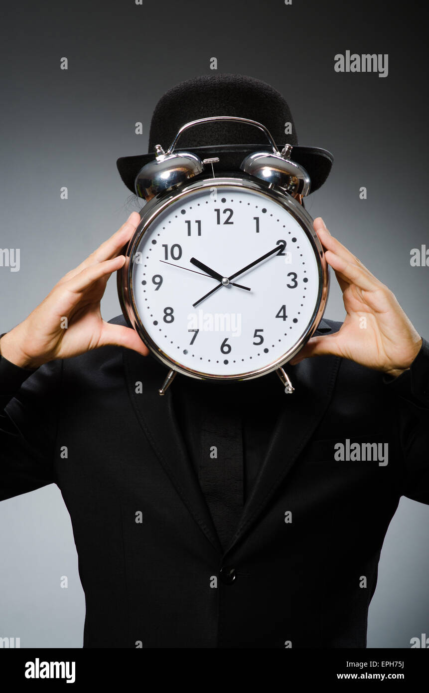 Man with clock wearing vintage hat Stock Photo - Alamy
