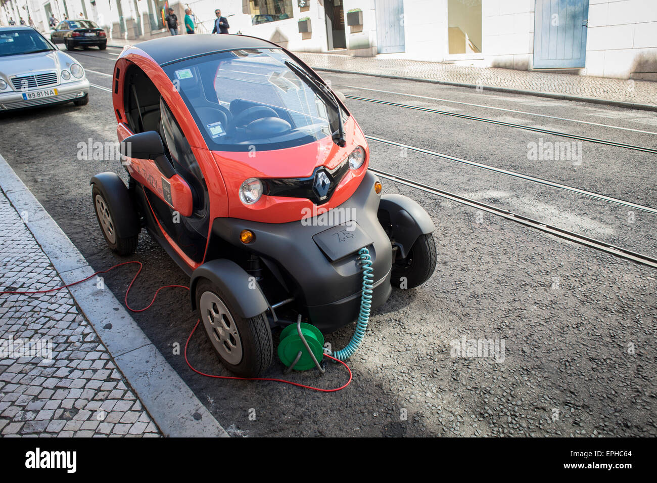 Renault ZE Twizy electric car parked in the street plugged in and charging Stock Photo