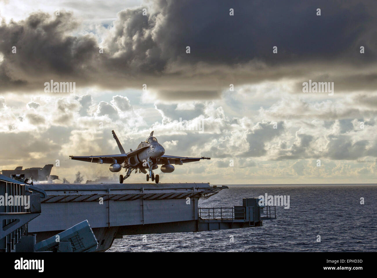 A U.S Navy F/A-18C Super Hornet fighter aircraft launches from the flight deck of the nuclear Nimitz-class aircraft carrier USS Carl Vinson during during operations May 13, 2015 in the Celebus Sea, Philippines. Stock Photo