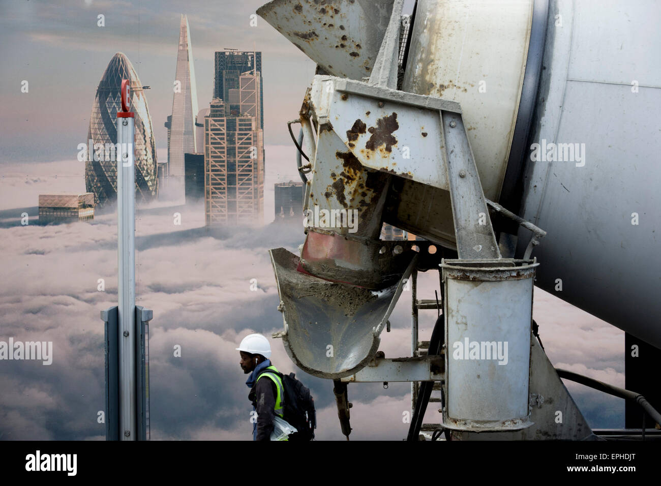 Cement mixer lorry and construction workman beneath a property