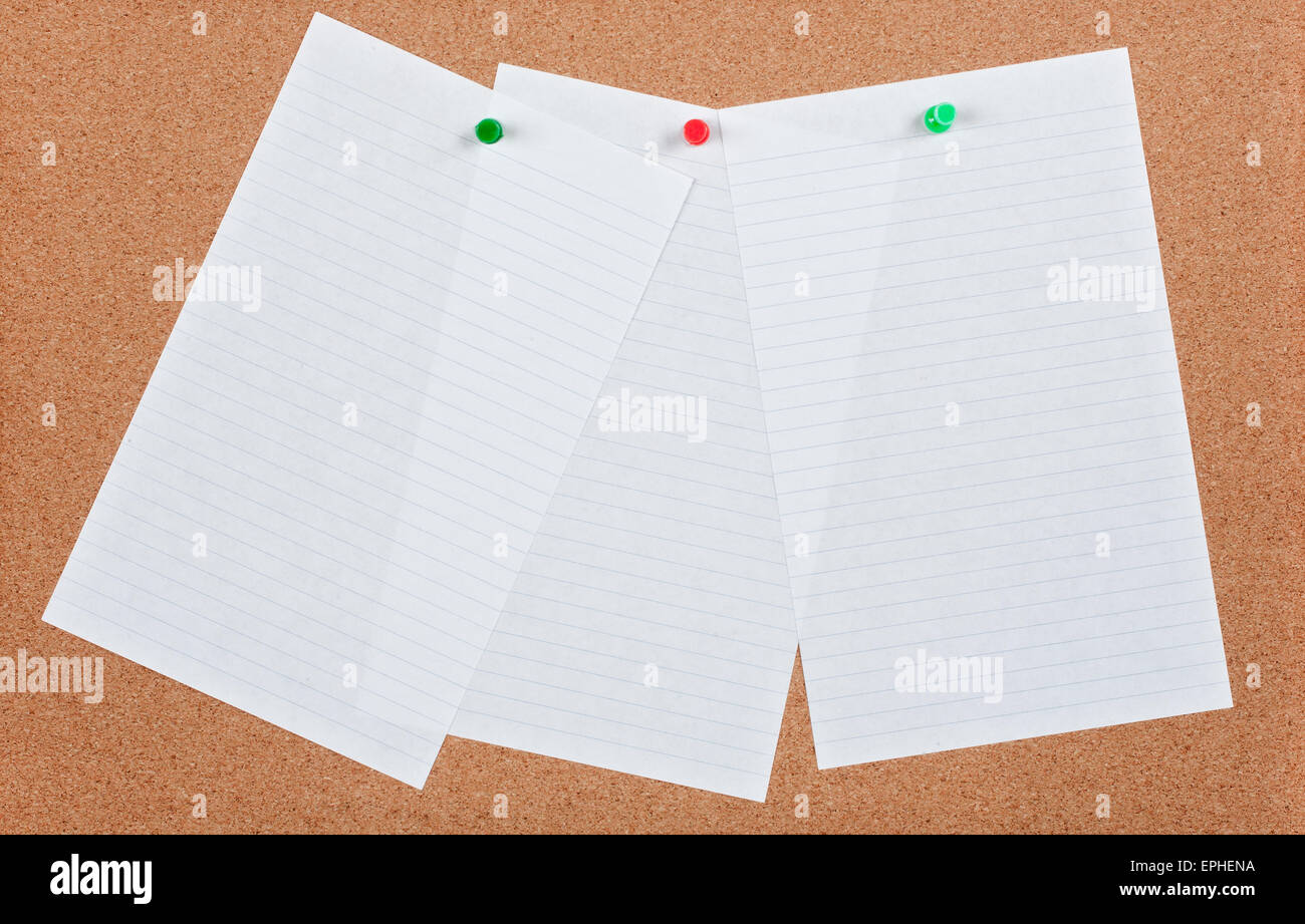 Three sheets of ruled  note paper pinned on cork board. Stock Photo