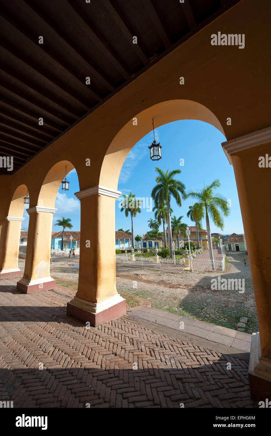 View of the Plaza Mayor between archways in the portico of the historic colonial architecture in Trinidad Cuba Stock Photo