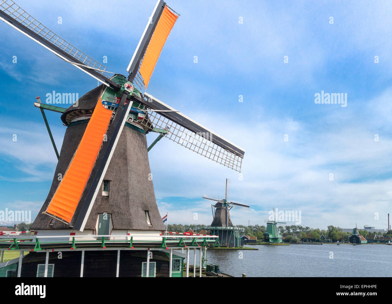 Holland windmills at De Zaanse Schans. Spinning oil mill windmill. Working old Dutch windmills along the river De Zaan. Stock Photo