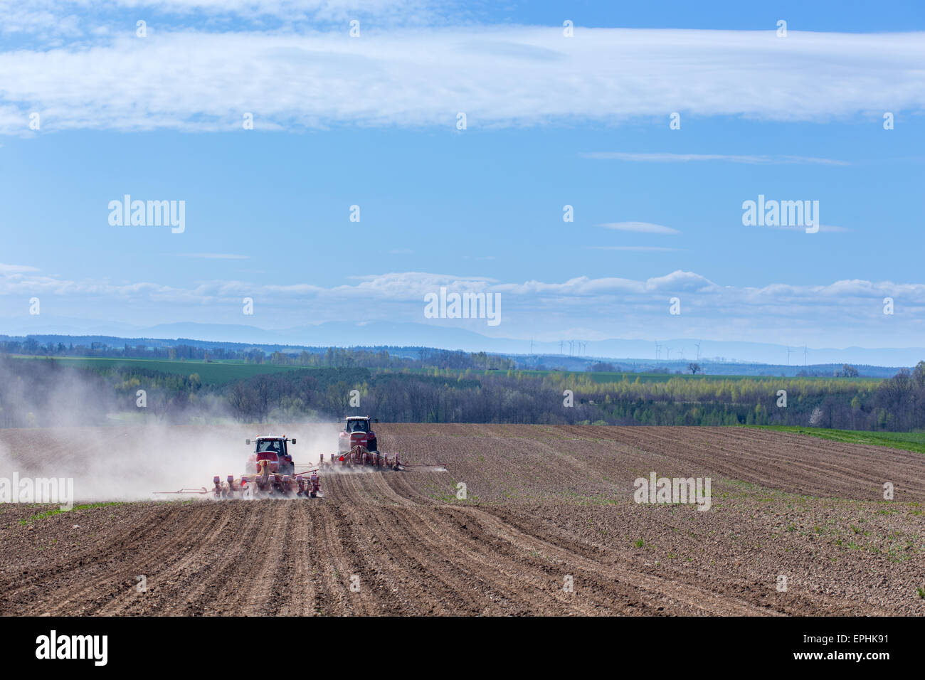 The tractor harrowing the large brown field in spring season Stock ...