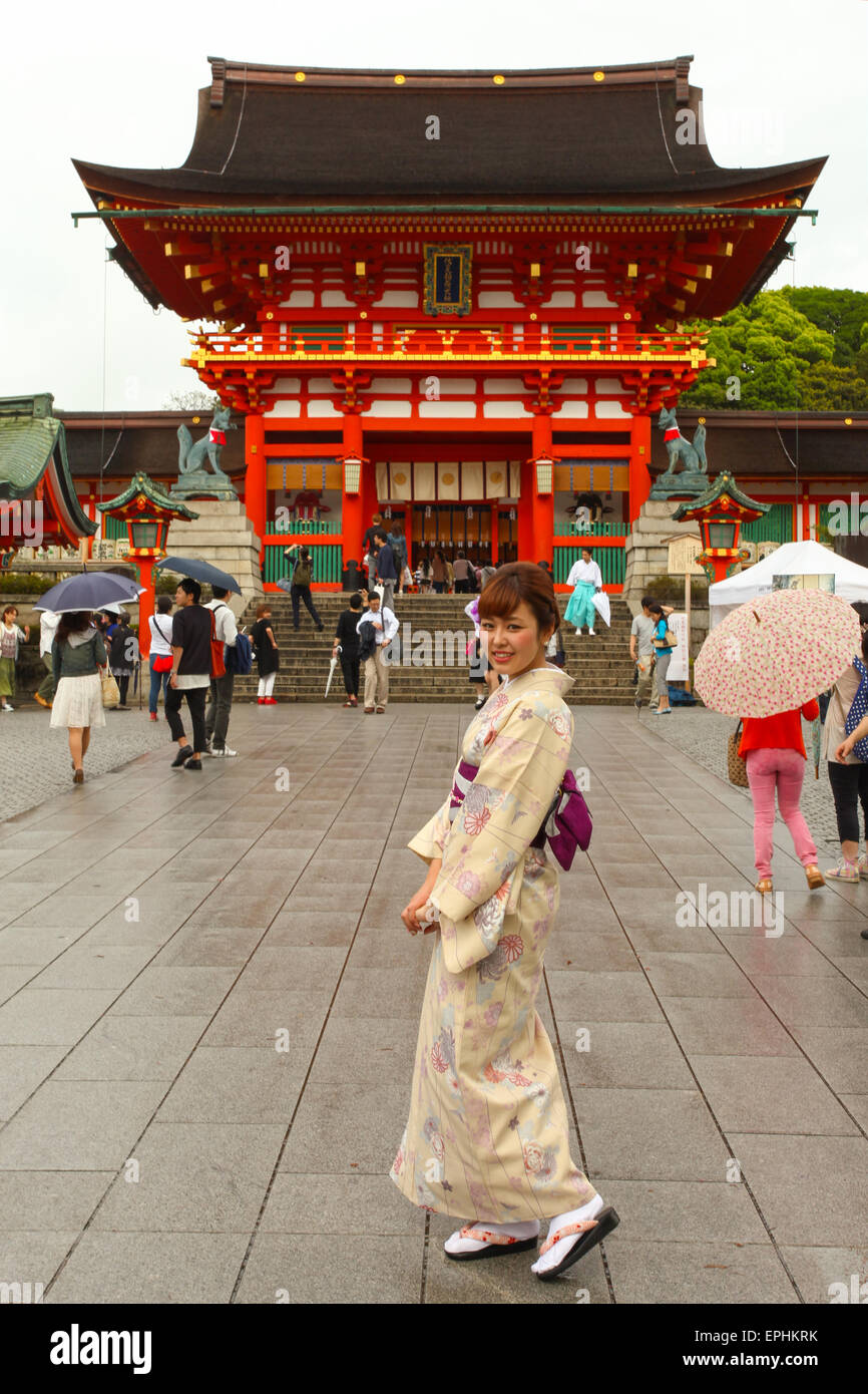 Japanese Geisha at Fushimi Inari Shrine gardens  in Kyoto. The road to the top of the mountain is reachable by a pat Stock Photo