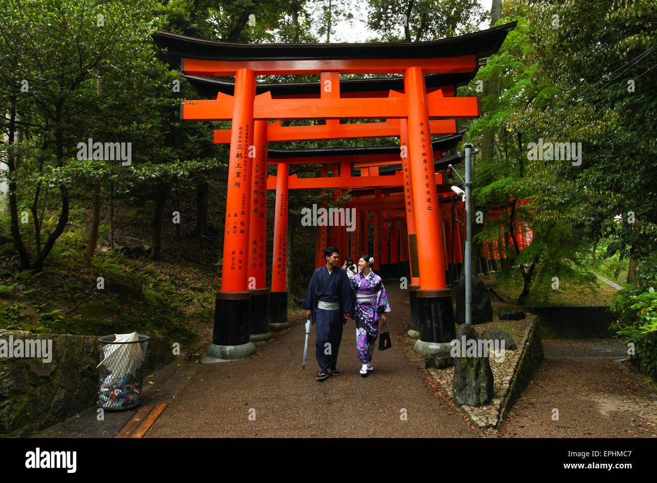 Japanese Geisha and partner at Fushimi Inari Shrine gardens  in Kyoto. Stock Photo
