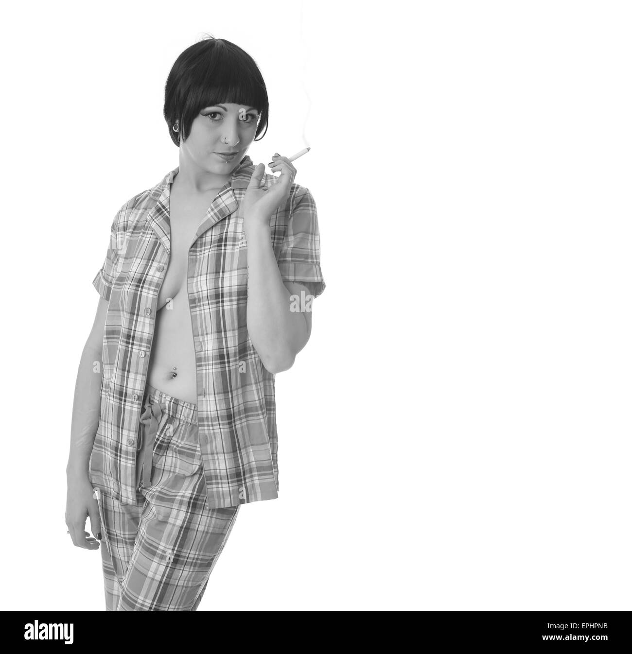 May 2015 - Beautiful young woman in traditional pajamas relaxing and having a cigarette Stock Photo