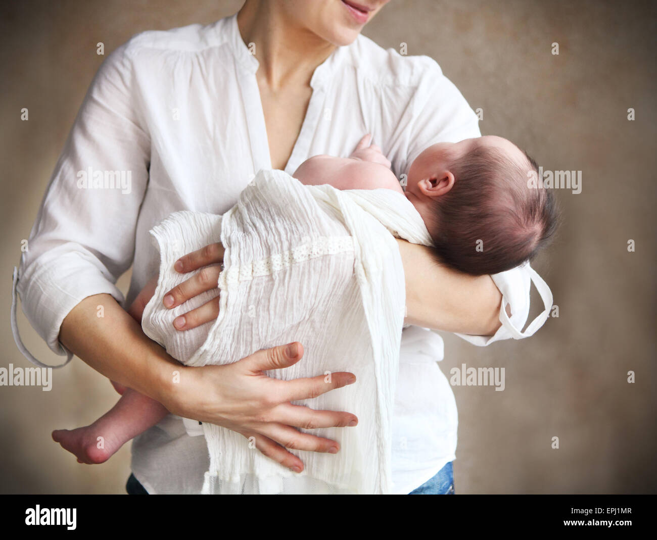 Baby falling asleep in the arms of her mother Stock Photo Alamy