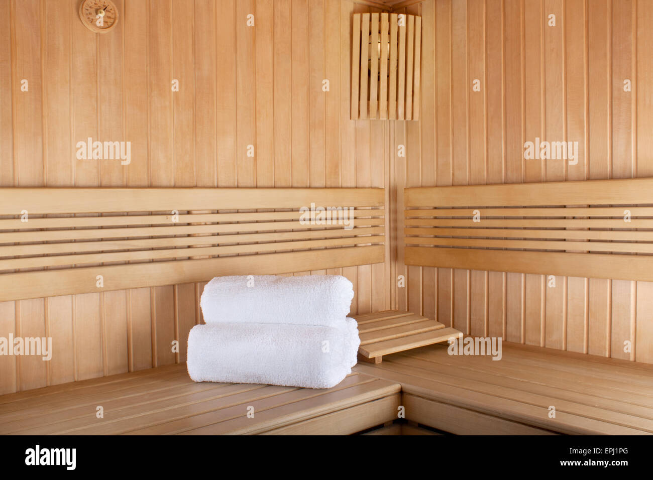 Traditional wooden sauna for relaxation with set of clean towels Stock Photo