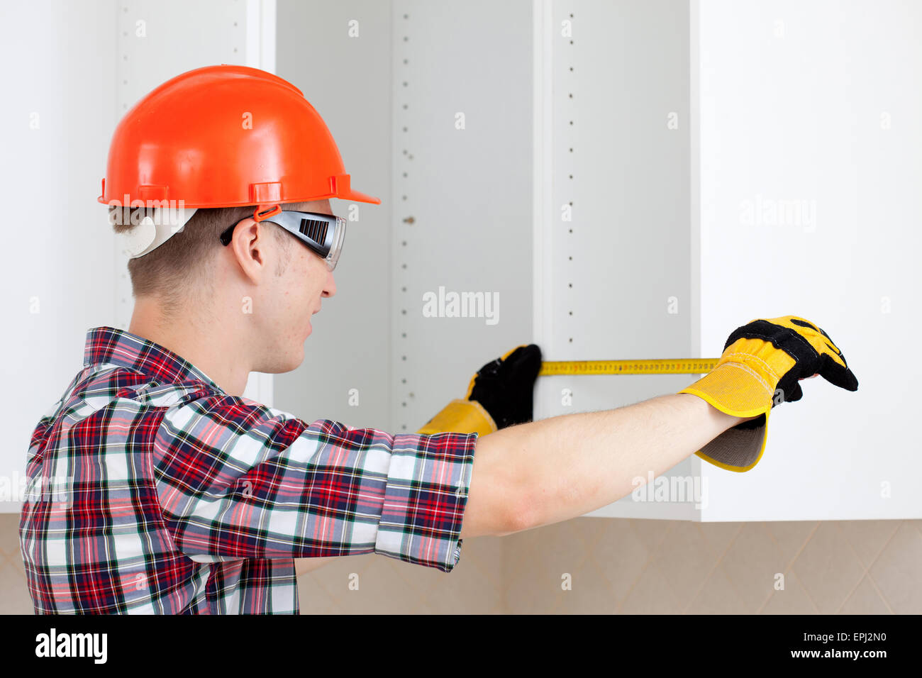 Builders Using Measure builder measures the length Stock Photo - Alamy