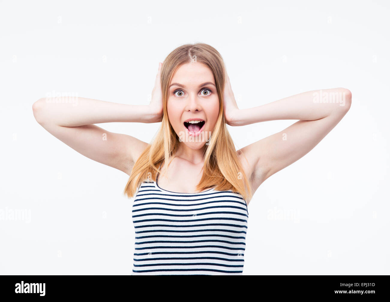 Surprised young woman covering her ears wit hands over gray background ...