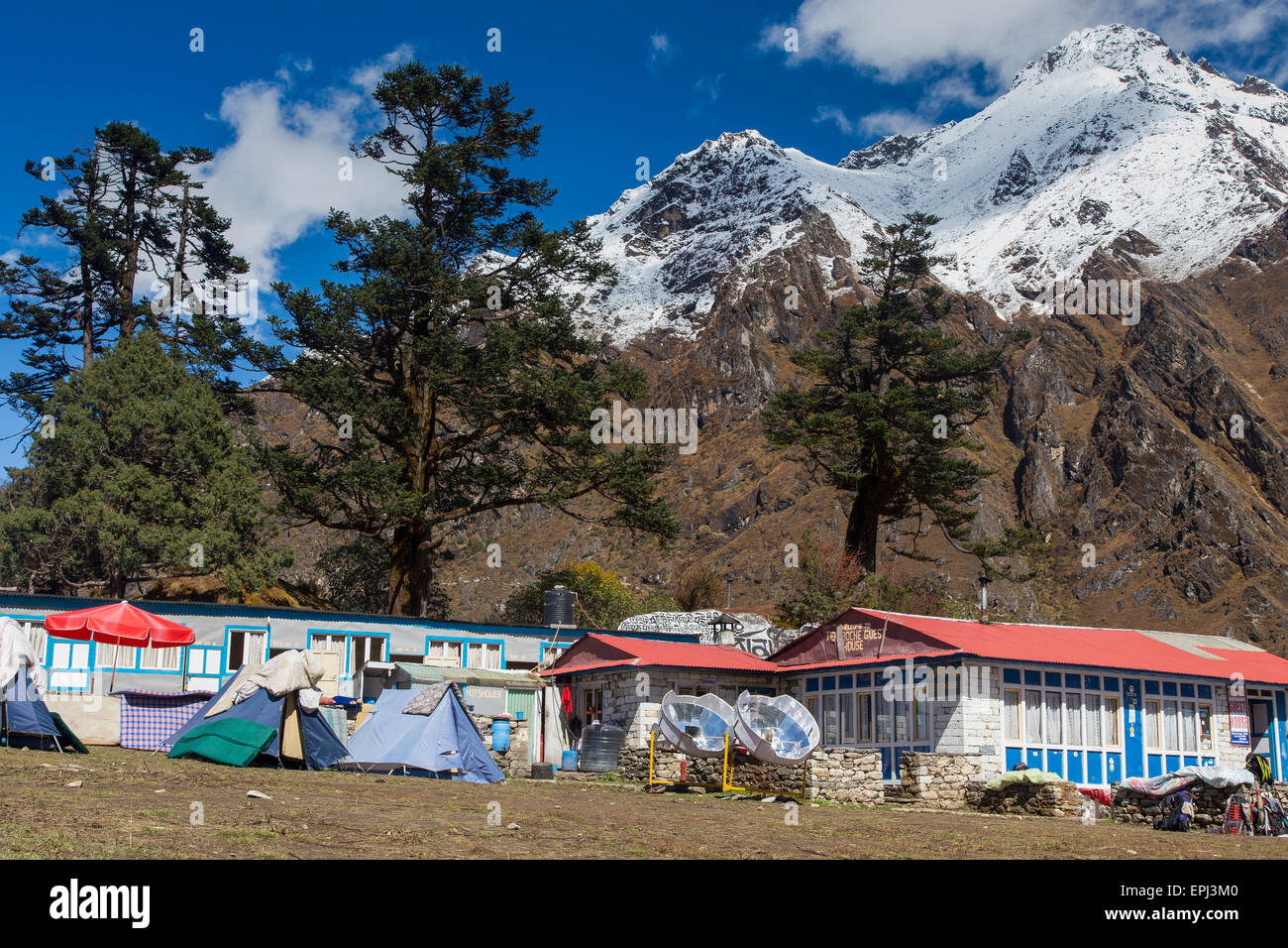 camping area with two solar cookers outside trekking lodges at the monastery in Tengboche, Everest Region Nepal Stock Photo