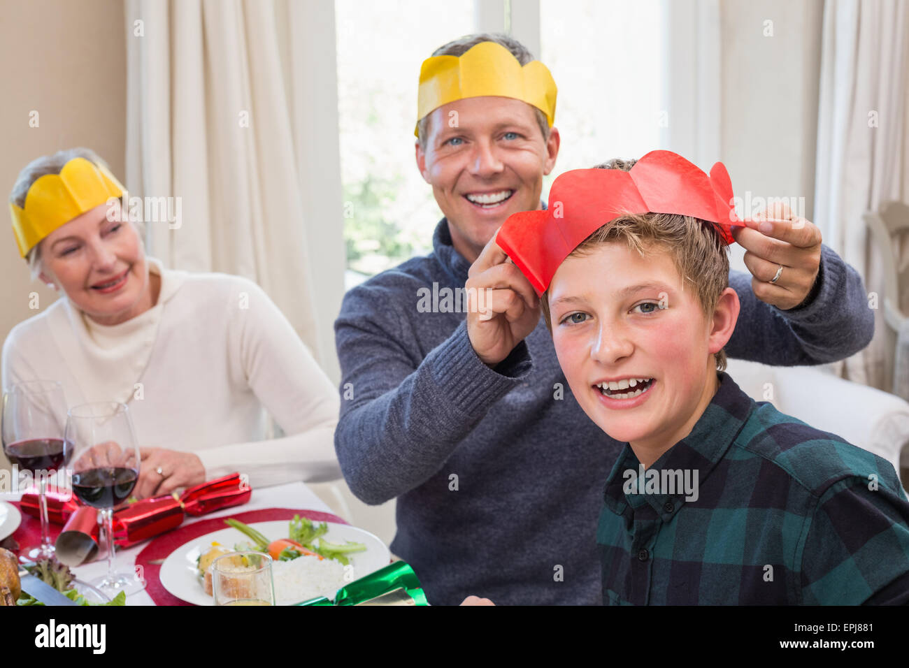 Smiling father putting party hat on sons head Stock Photo Alamy