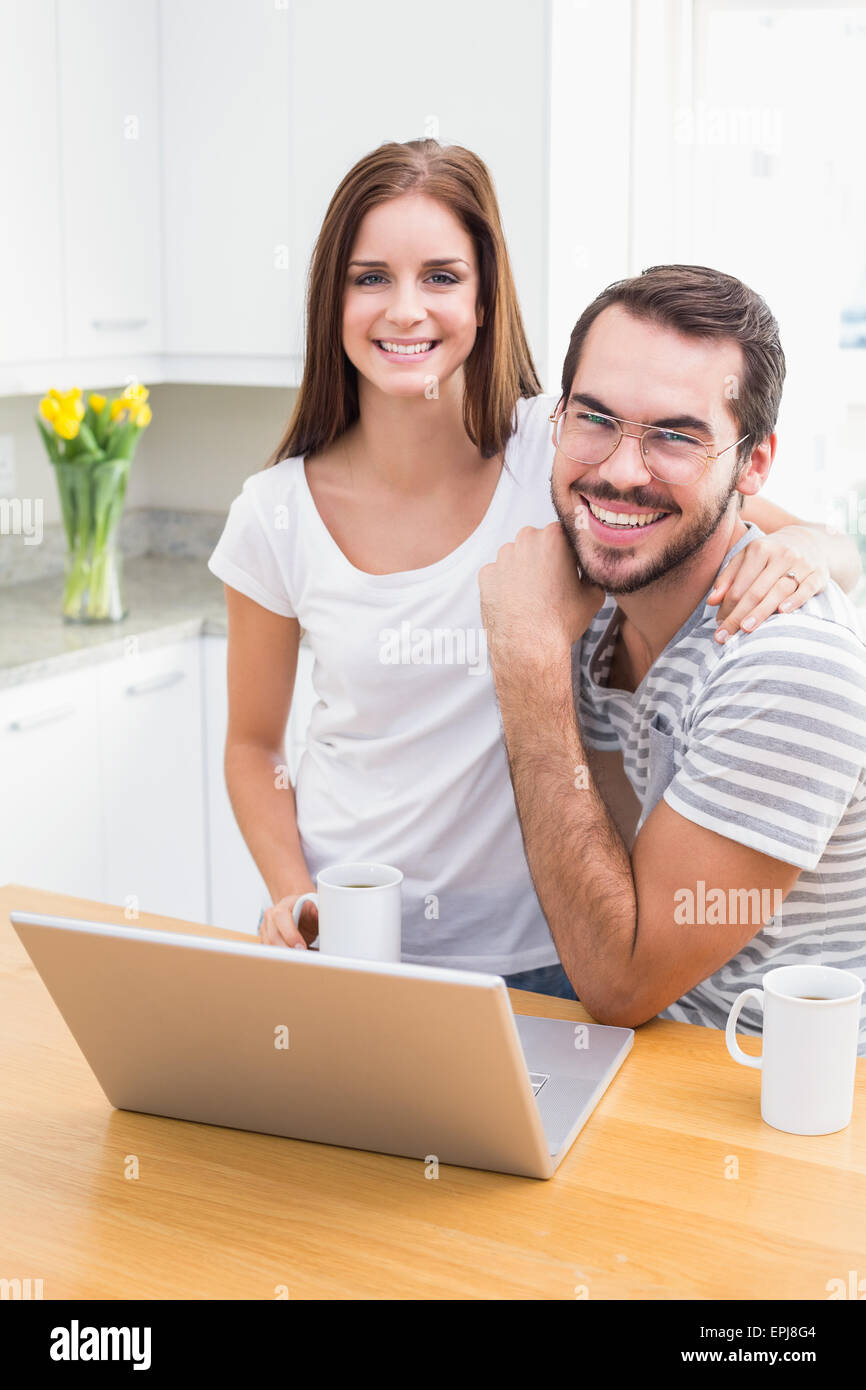 Young couple smiling at the camera using laptop Stock Photo - Alamy