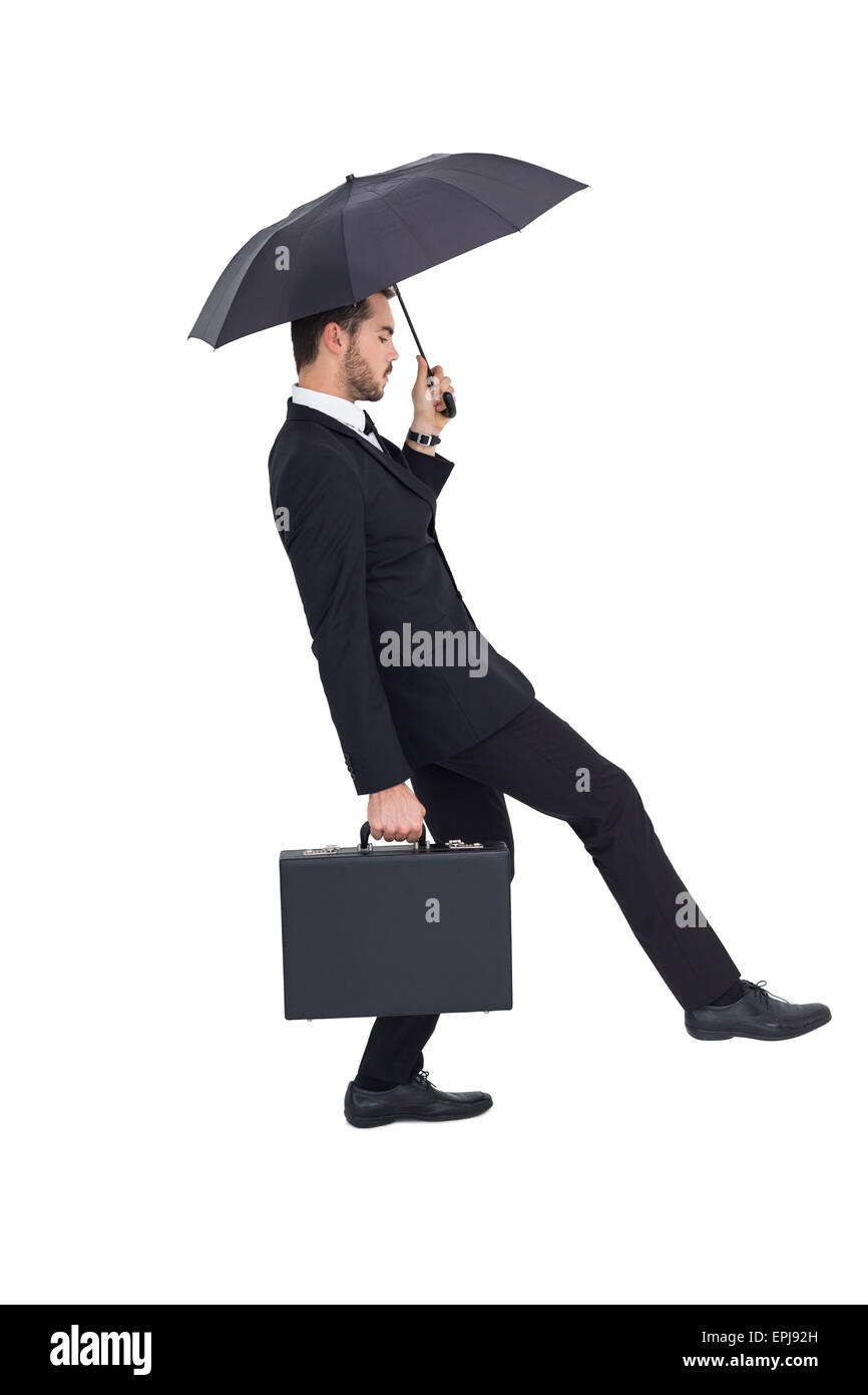 Businessman holding briefcase under umbrella Stock Photo Alamy