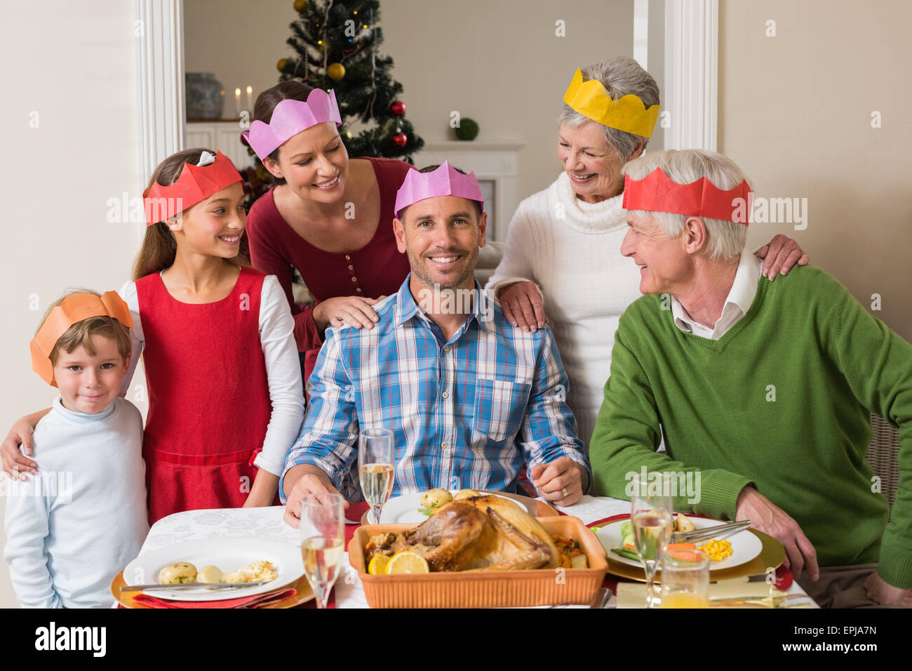 Cheerful extended family in party hat at dinner table Stock Photo Alamy
