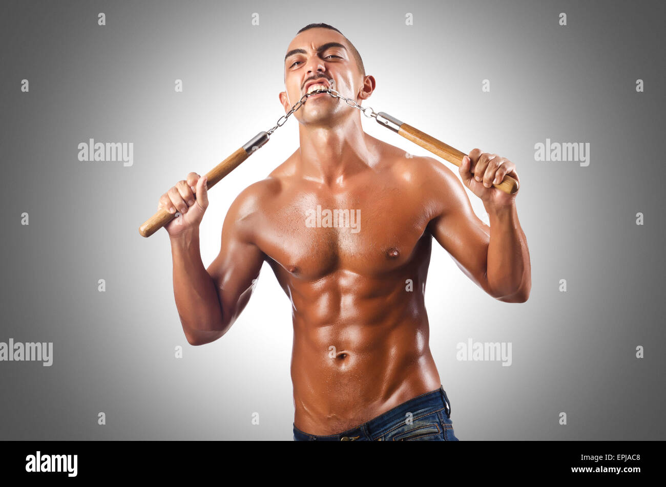 Man in martial arts concept with nunchucks Stock Photo Alamy