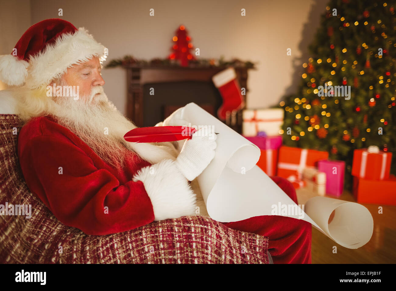 Santa claus writing his list on scroll Stock Photo